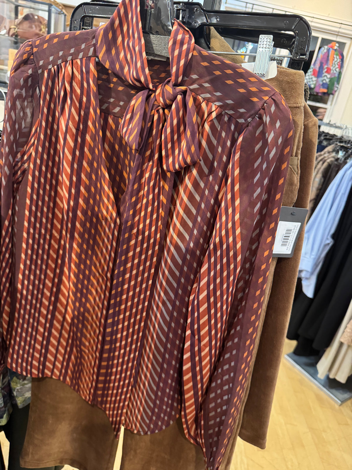 Tie blouse in cranberry color in clothing store