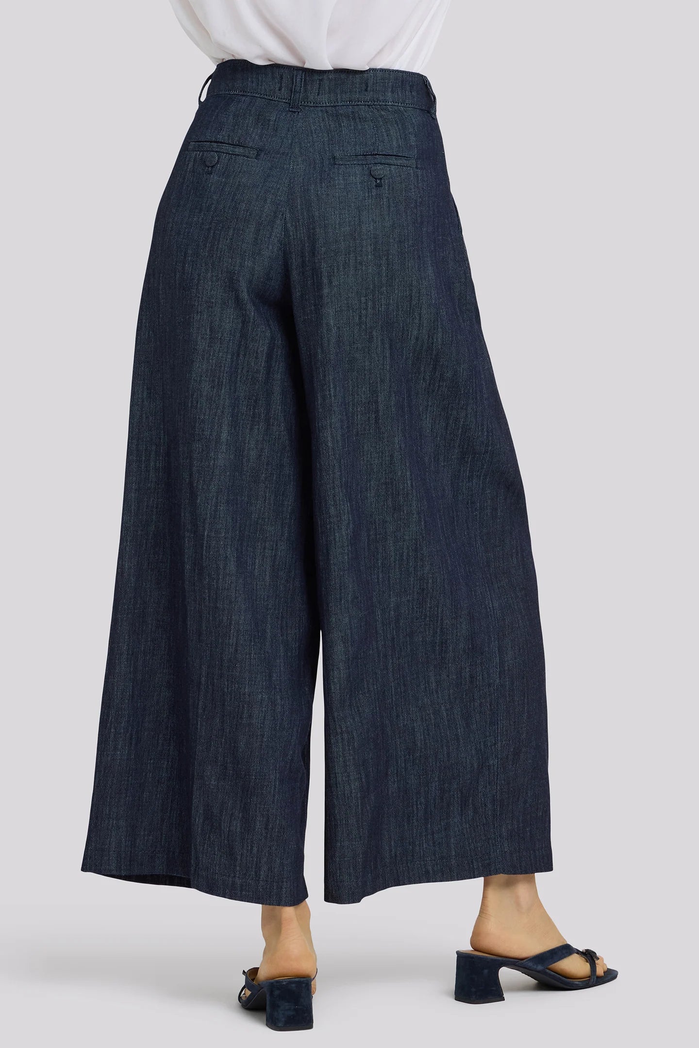 Dark blue wide-leg jeans worn by a person on a white background