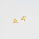 Pair of gold-tone letter A initial stud earrings on a light background