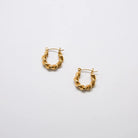 Pair of gold-tone oval twist hoop earrings with a textured twisted design