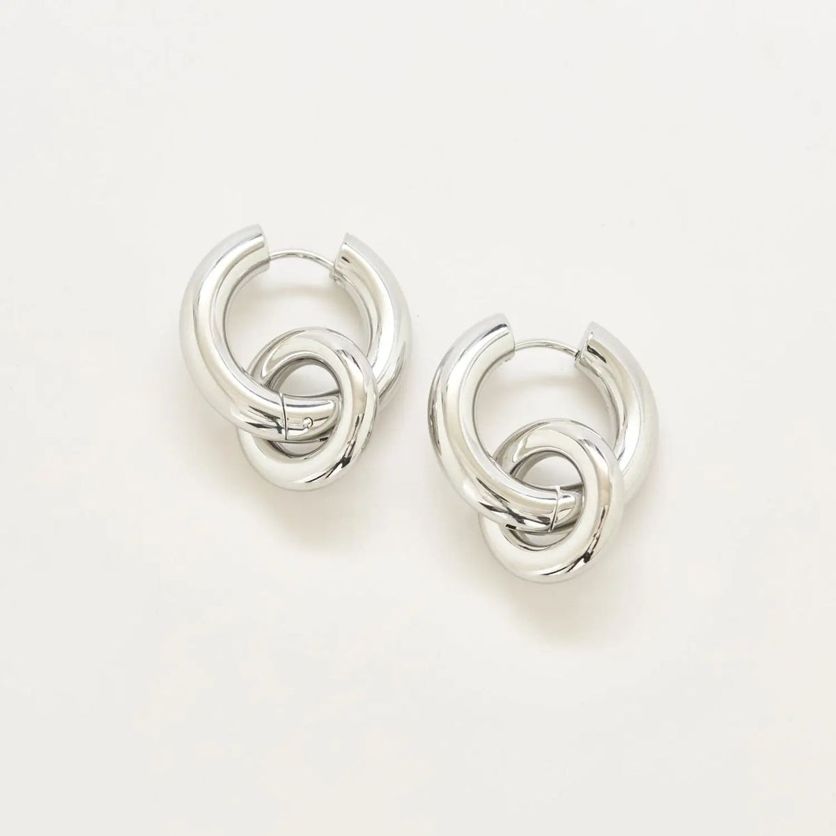 Silver interlocking hoop earrings on a white background