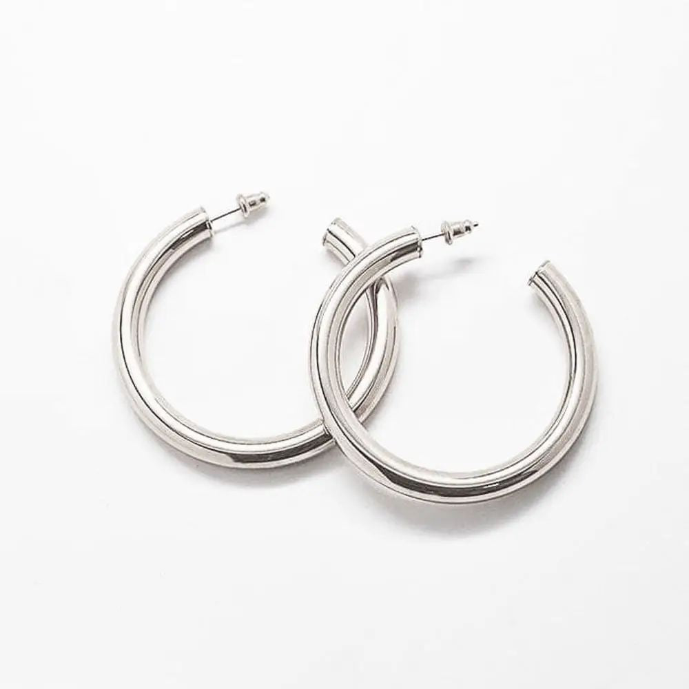 Pair of medium silver-tone hoop earrings on a light background