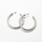 Pair of medium silver-tone hoop earrings on a light background