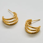 Gold triple arc hoop earrings on a white background