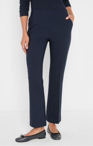 A model wearing a pair of dark navy blue cropped trousers with a straight-leg fit, paired with a matching navy long-sleeve top and black flat shoes, against a plain white studio background.