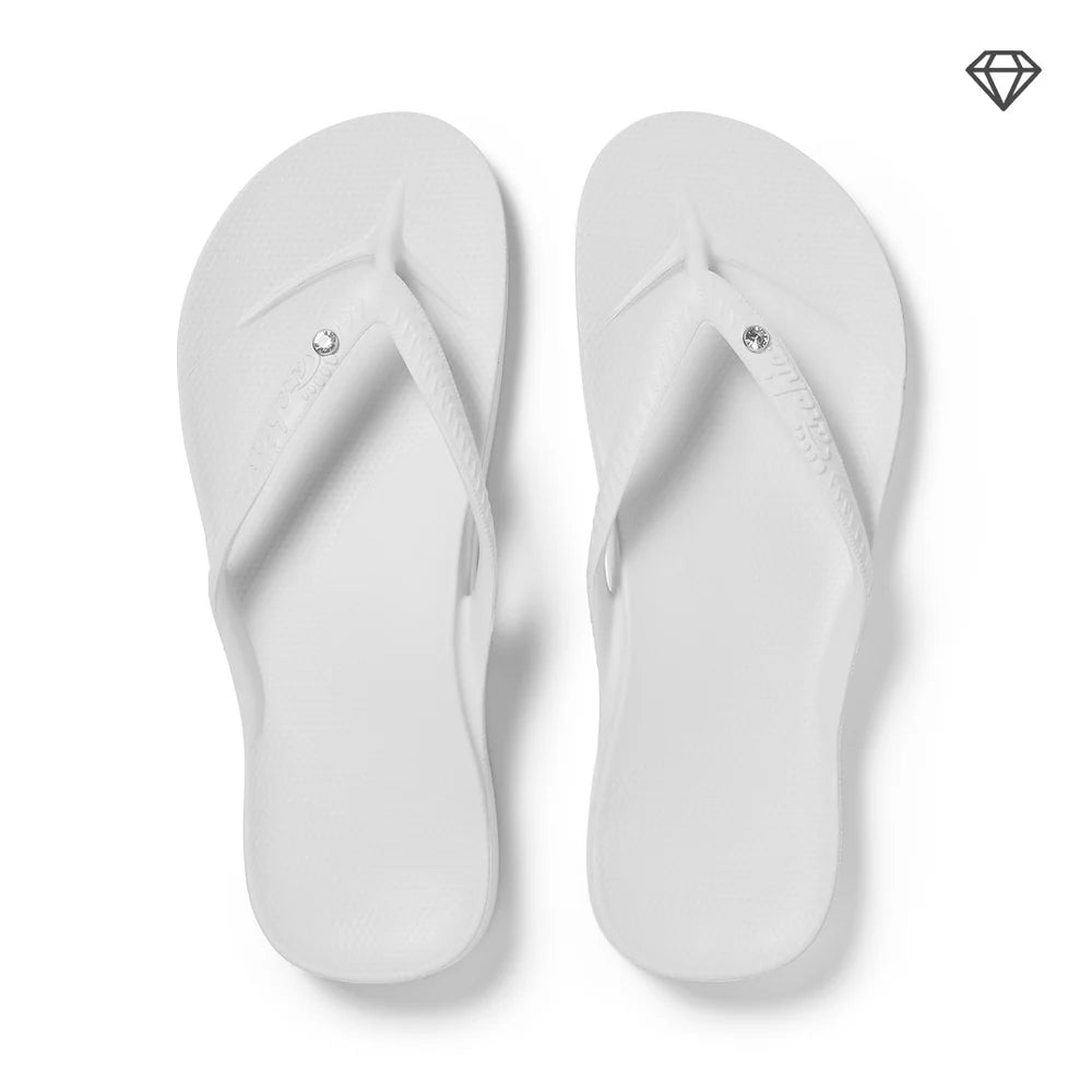 White flip-flops with crystal embellishments on a white background