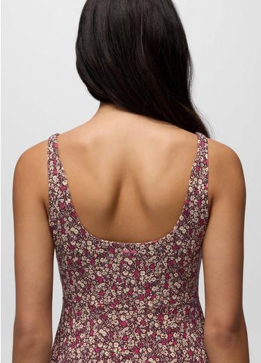 Back view of a person wearing a floral dress with thin straps on a plain background