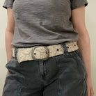 woman wearing a wool  beige belt with black jeans and a grey tshirt 