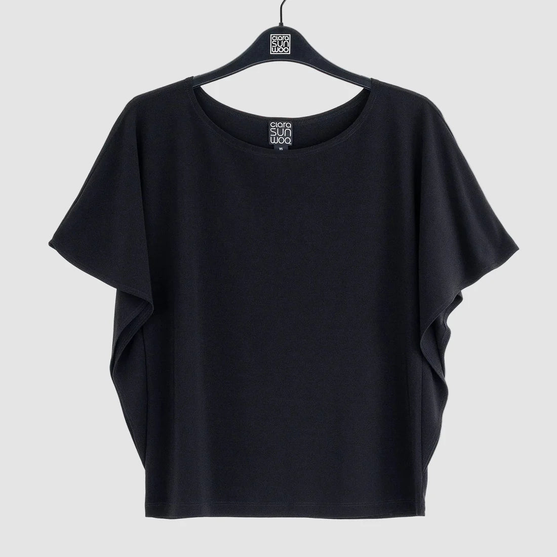 Black t-shirt on a hanger against a white background