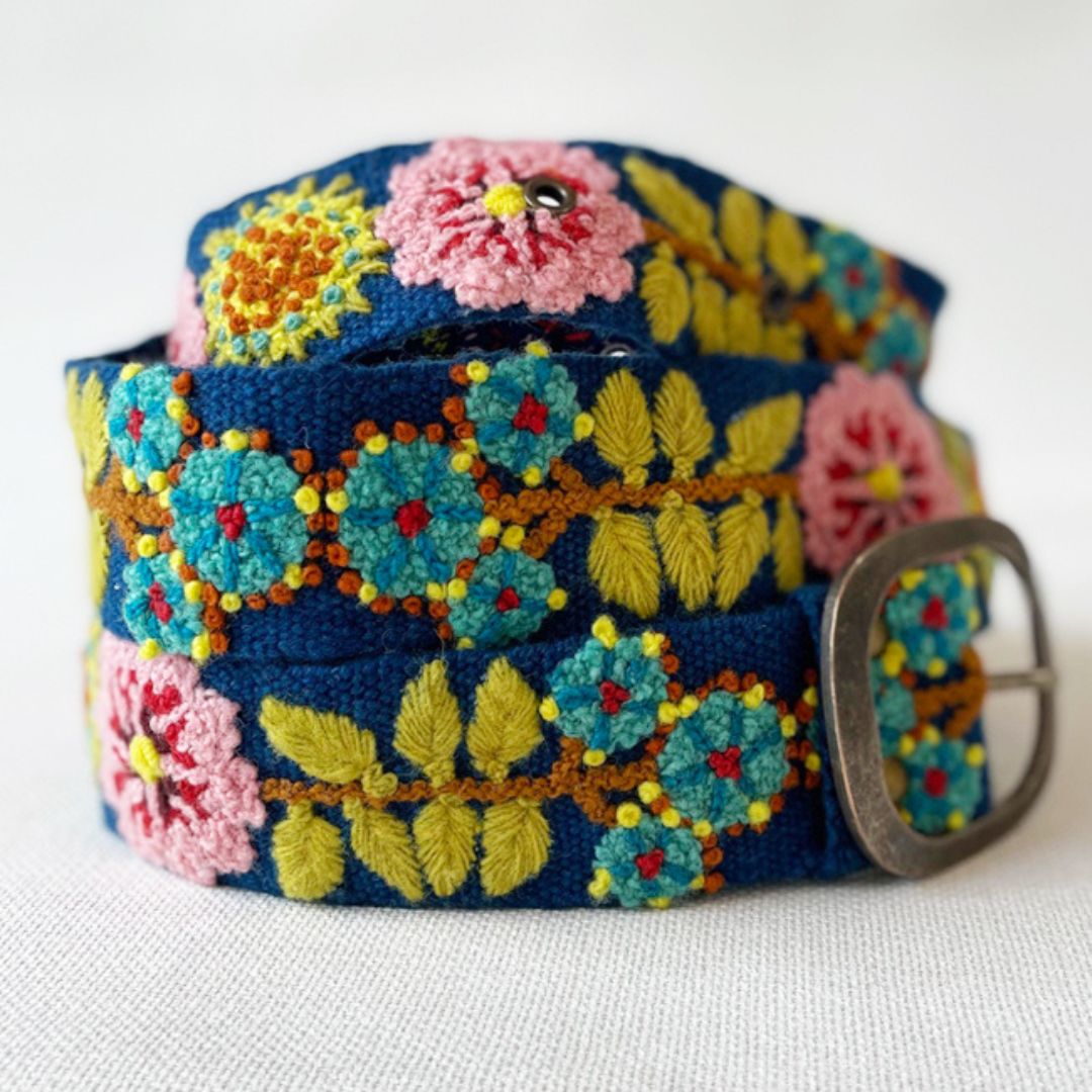 Colorful floral embroidered belt with a metal buckle on a white background