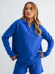 woman wearing a matching bright blue top and short set with white background