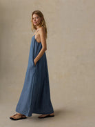 Woman wearing Faherty Brand Tried & True Chambray Slip Dress in River Mist Wash styled with sandals for a coastal summer look