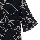 Close-up of the foiled black and taupe floral print