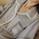 Close-up of the embroidered chest pocket on the grey flannel pajama top