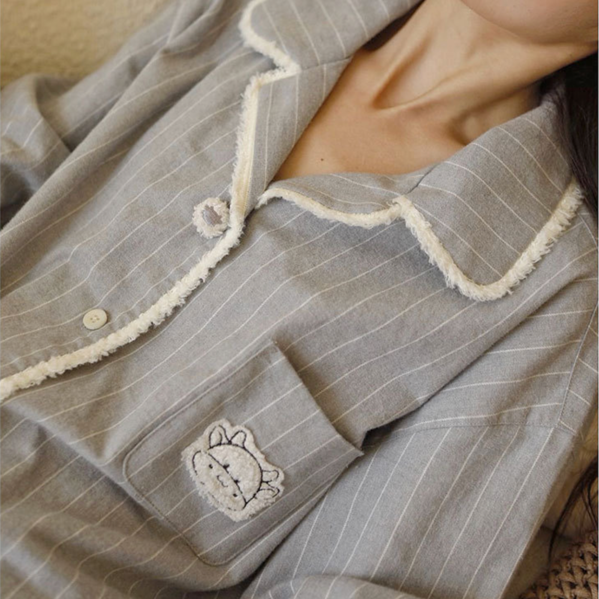 Close-up of the embroidered chest pocket on the grey flannel pajama top