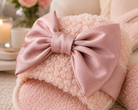 Close-up of the pink satin bow and curly faux wool texture