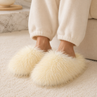 Ivory shaggy faux fur slippers worn with cream loungewear