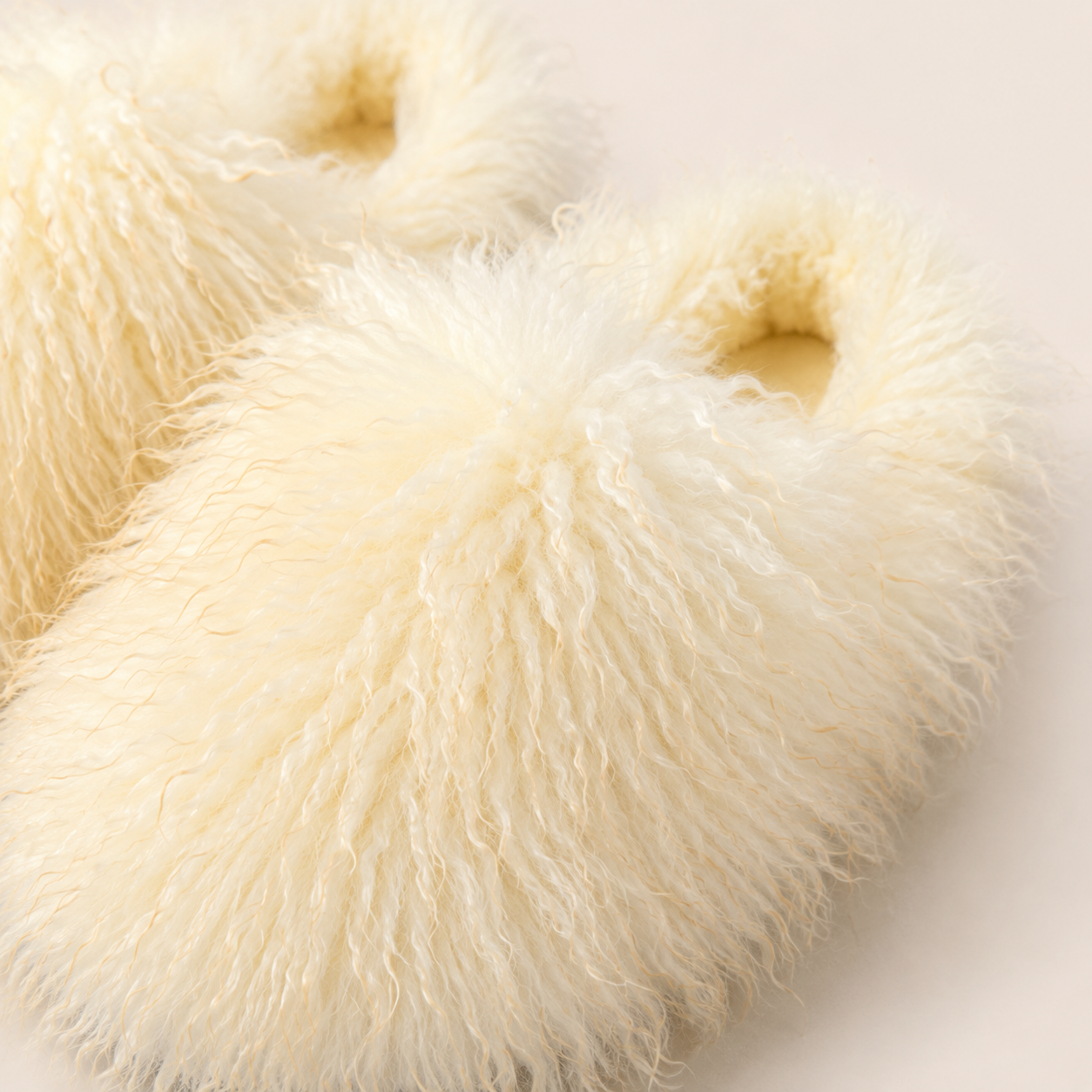 Close-up of the shaggy faux fur texture on the ivory slippers