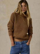 Woman wearing the Faherty Sunwashed Cotton Turtleneck in Toasted Sun, a brown ribbed knit, with blue jeans