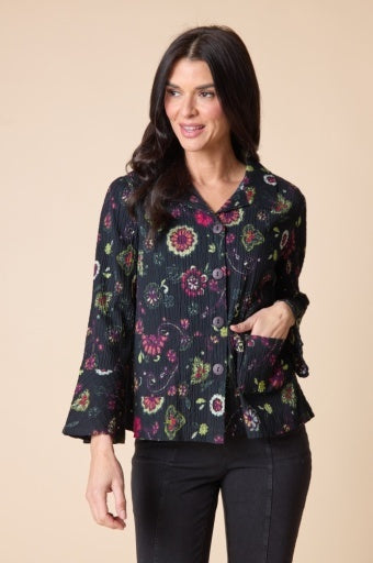 Woman wearing a floral patterned blouse against a beige background