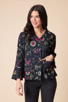 Woman wearing a floral patterned blouse against a beige background