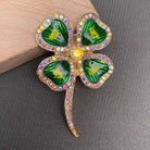 Four-leaf clover brooch with gemstones on a gray surface