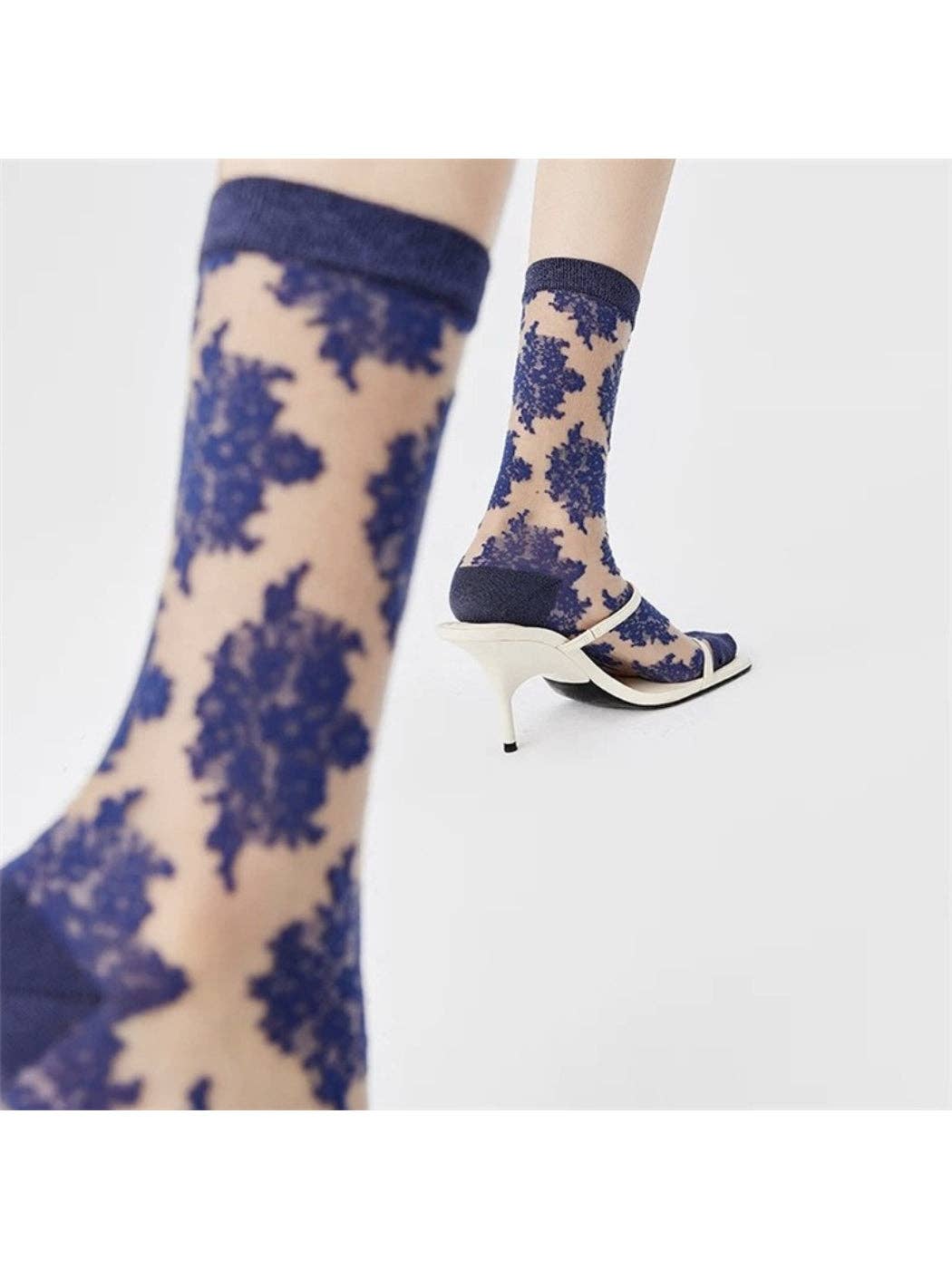 Close-up of the flocked floral pattern on blue sheer socks
