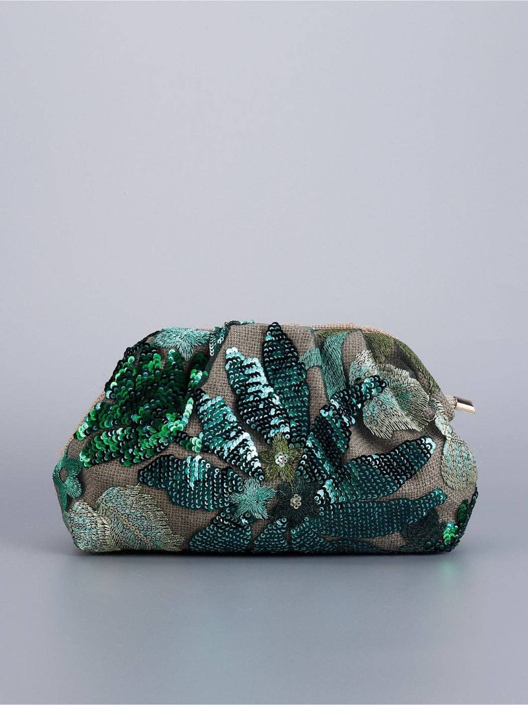 Green floral sequin evening clutch styled on a table