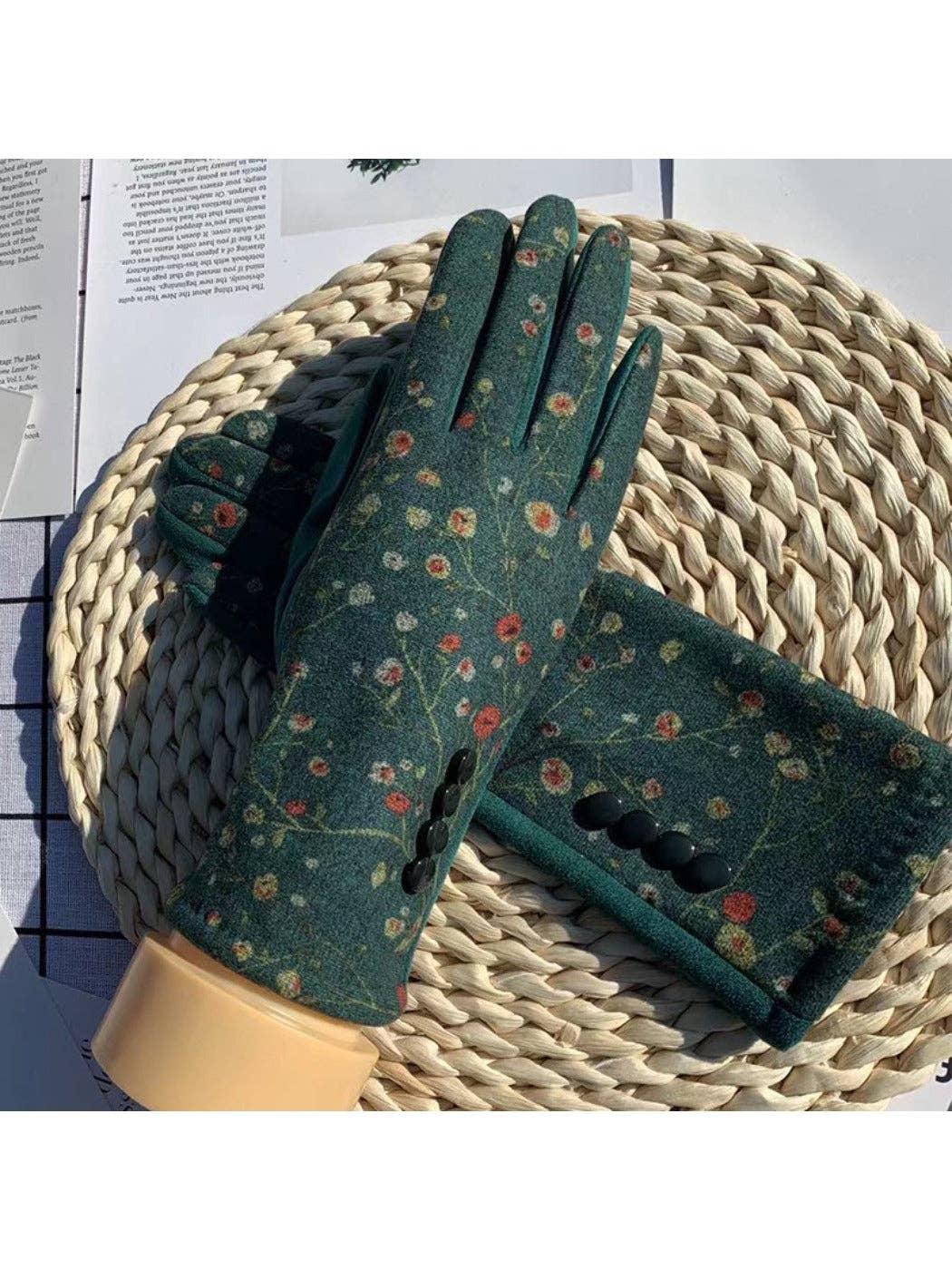 Green floral touchscreen gloves styled on a woven basket