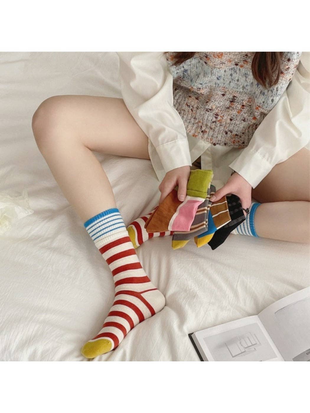 Red stripe patchwork socks worn on the bed