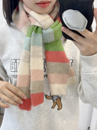Pastel striped fuzzy scarf worn with a cream sweater