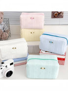 Textured cosmetic pouches in pastel colors with small rose detail