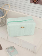 Textured cosmetic pouch with rose detail, product photo