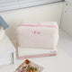 Textured cosmetic pouch with rose detail, alternate view
