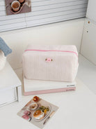 Pink textured cosmetic pouch with rose detail
