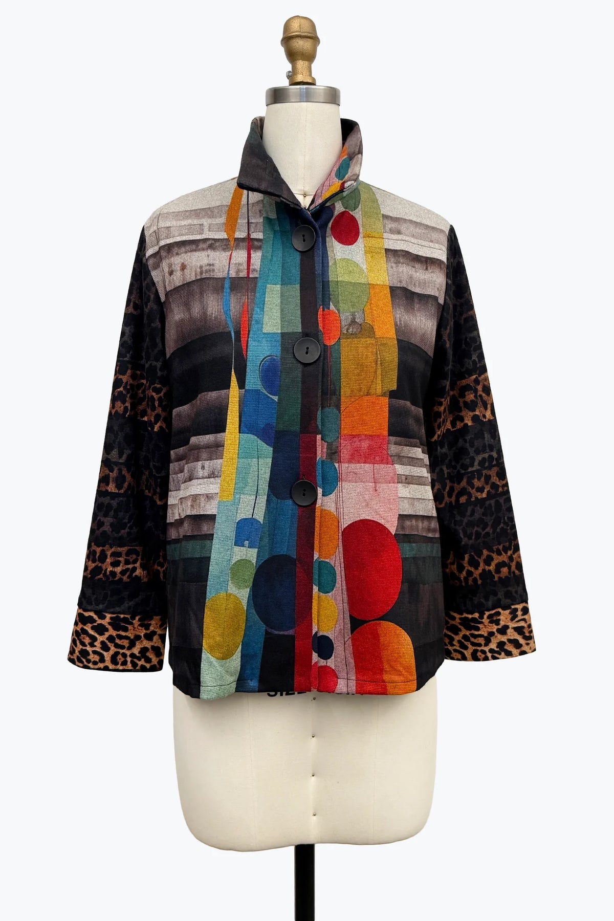 A multicolor abstract print jacket with leopard print cuffs, displayed on a cream dress form mannequin against a white background.