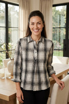 Woman wearing the Habitat Crinkle Windowpane Chill Pullover in winter white plaid with black pants, front view