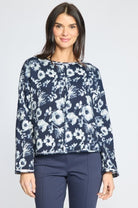 Woman wearing the Habitat Focus Floral Rolled Edge Pullover in navy with a white floral print, styled with dark pants