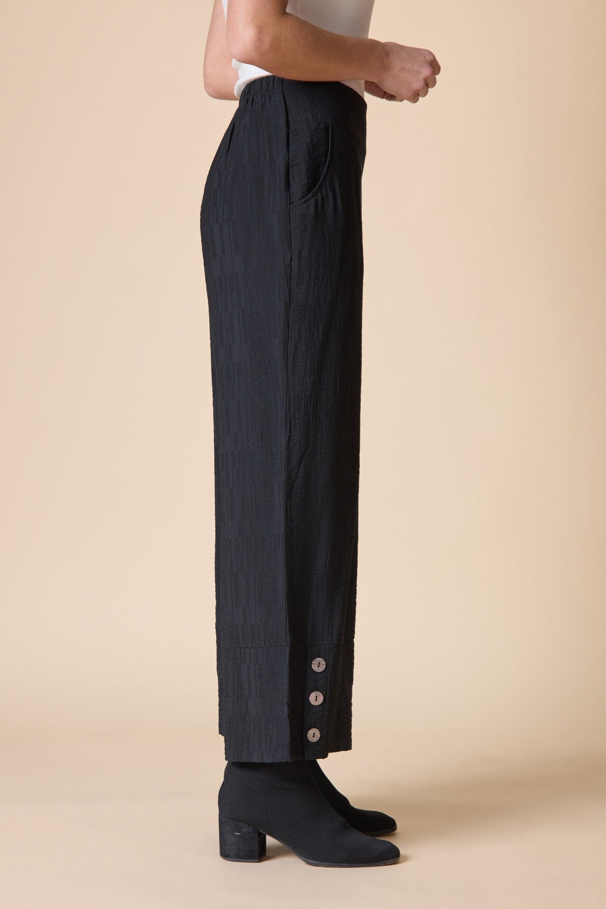 Side view of the Habitat Rayon Jacquard Button Hem Pant in black showing the button hem detail