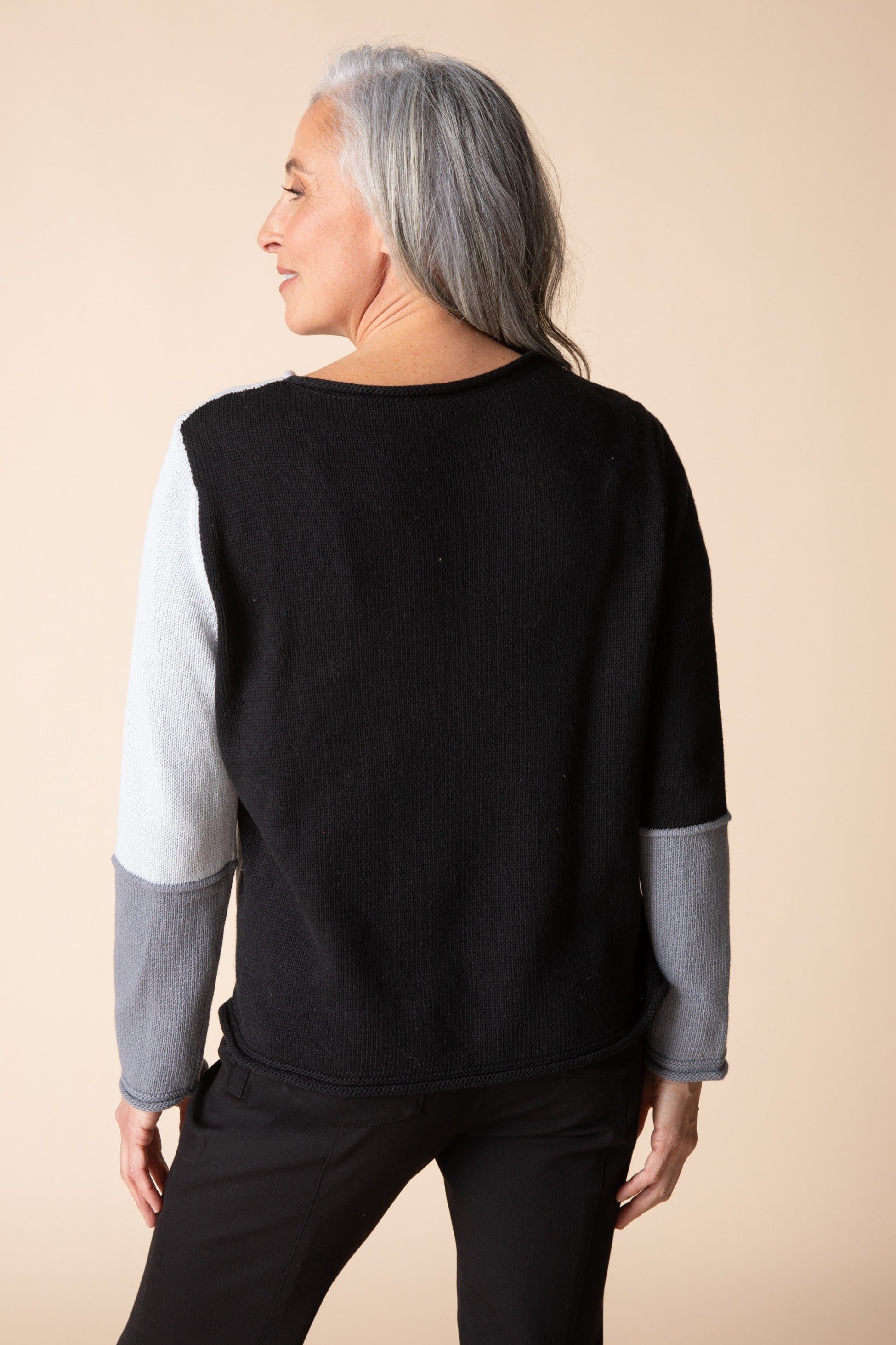 Back view of the Habitat Yin Yang Block Party Sweater in Mist, black body with grey color-block sleeves