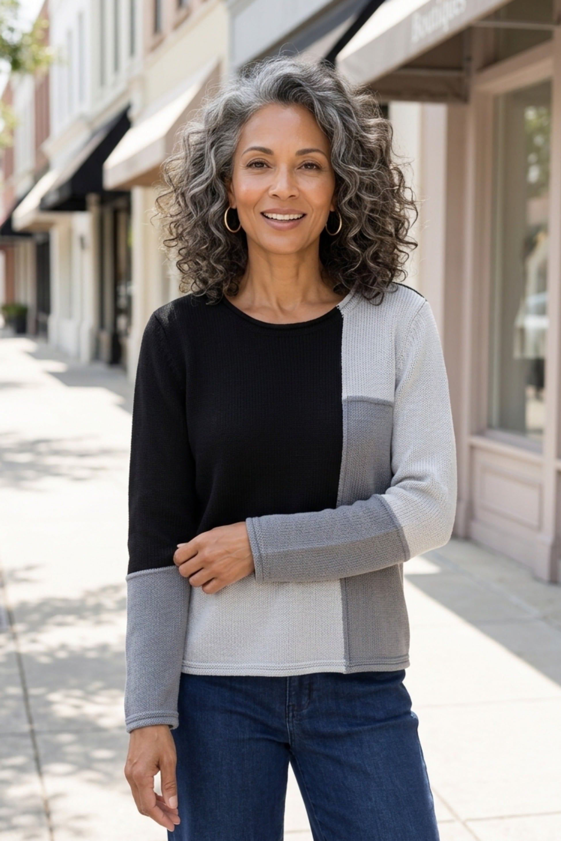 Habitat Yin Yang Block Party Sweater in Mist styled with jeans on a city sidewalk