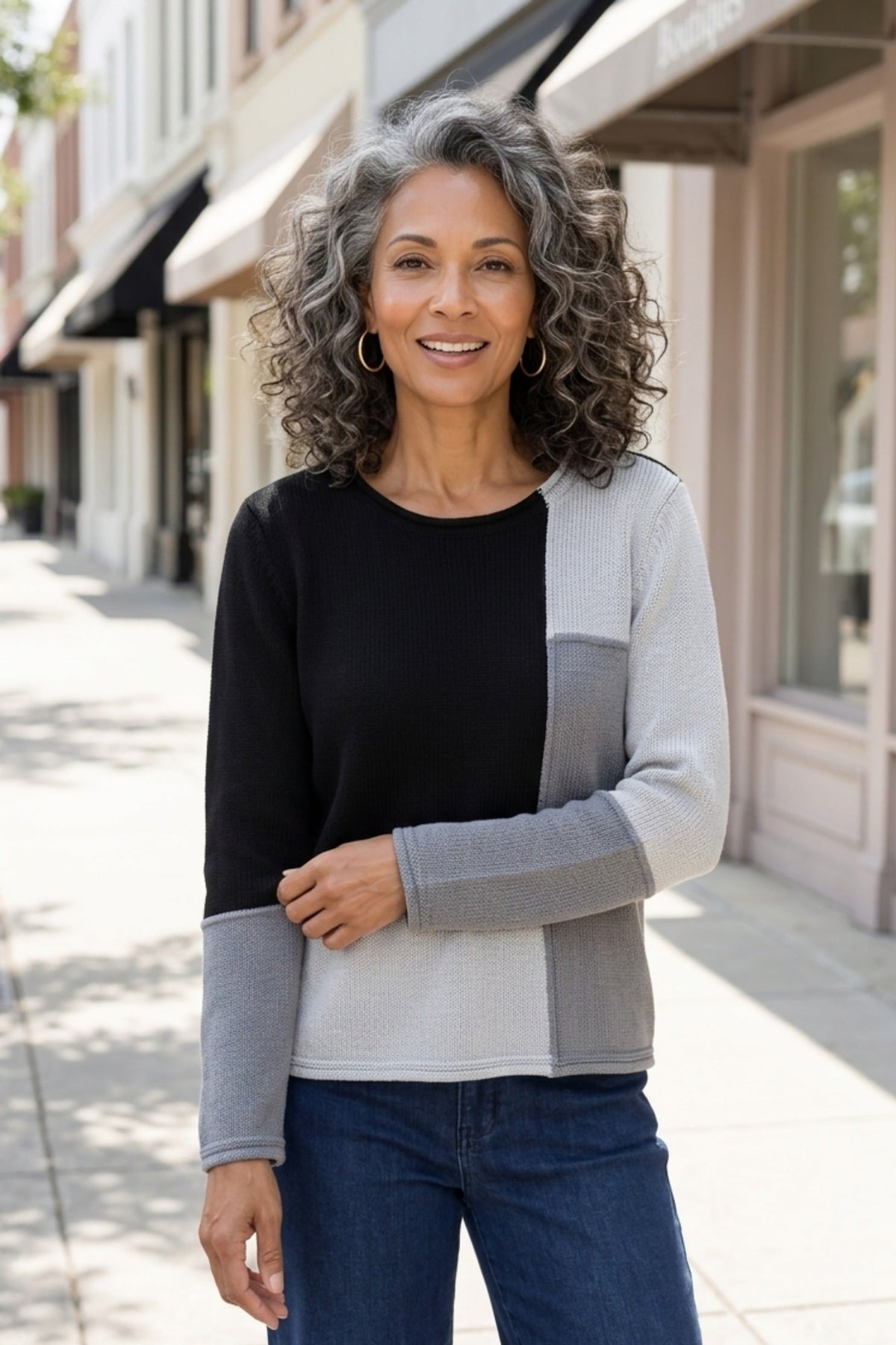 Habitat Yin Yang Block Party Sweater in Mist styled with jeans on a city sidewalk