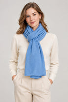 Model wearing the In Cashmere Classic Cashmere Scarf in Blue Skies, a soft light blue 100% cashmere