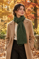 Model wearing the In Cashmere Classic Cashmere Scarf in Heather Pine, a deep green 100% cashmere