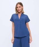 blue top on a woman with a white background