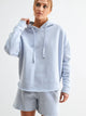 woman wearing a light blue hoodie and shorts set with white background