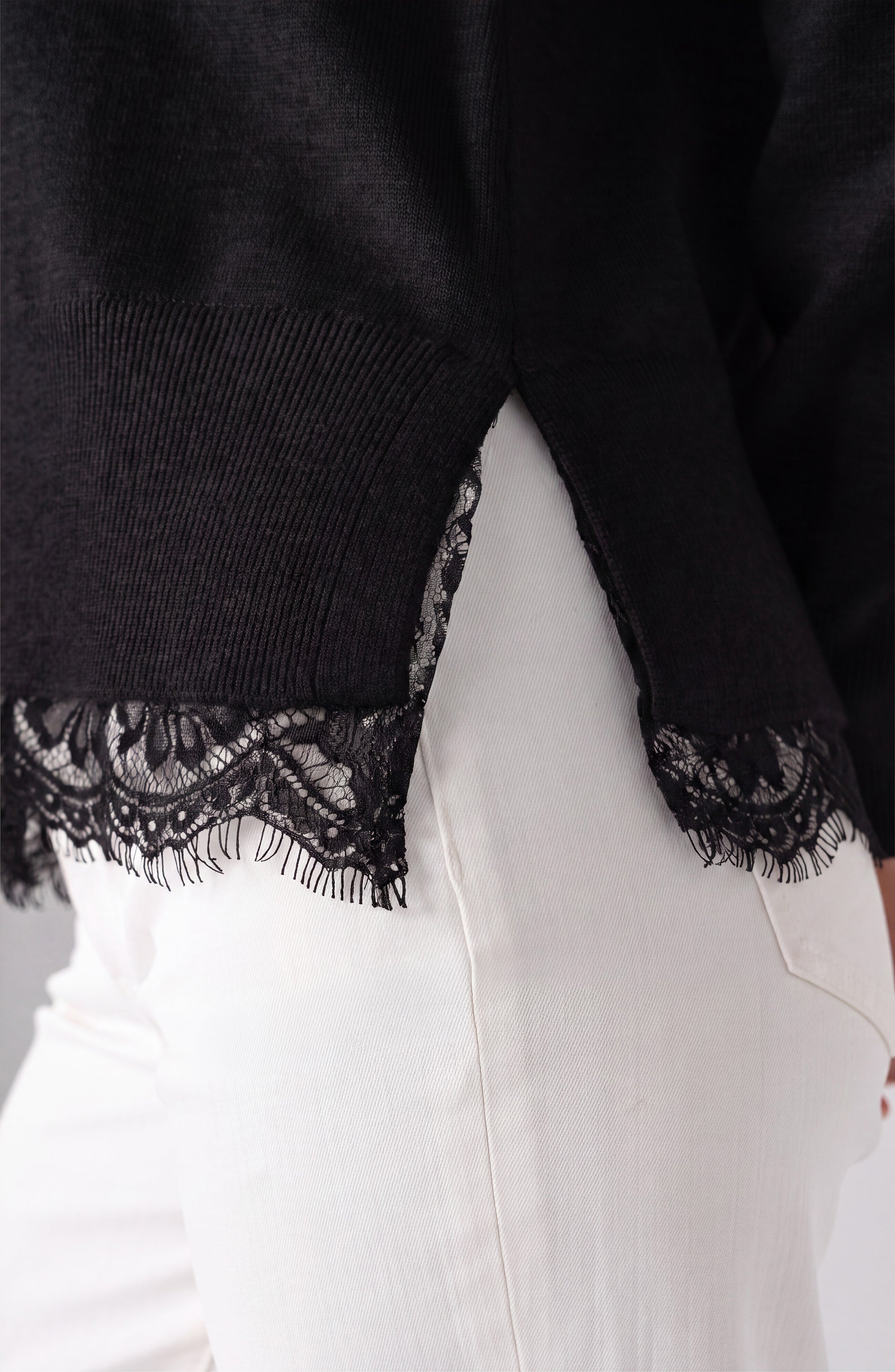 Close-up of the lace trim detail on the black Liverpool V-neck sweater