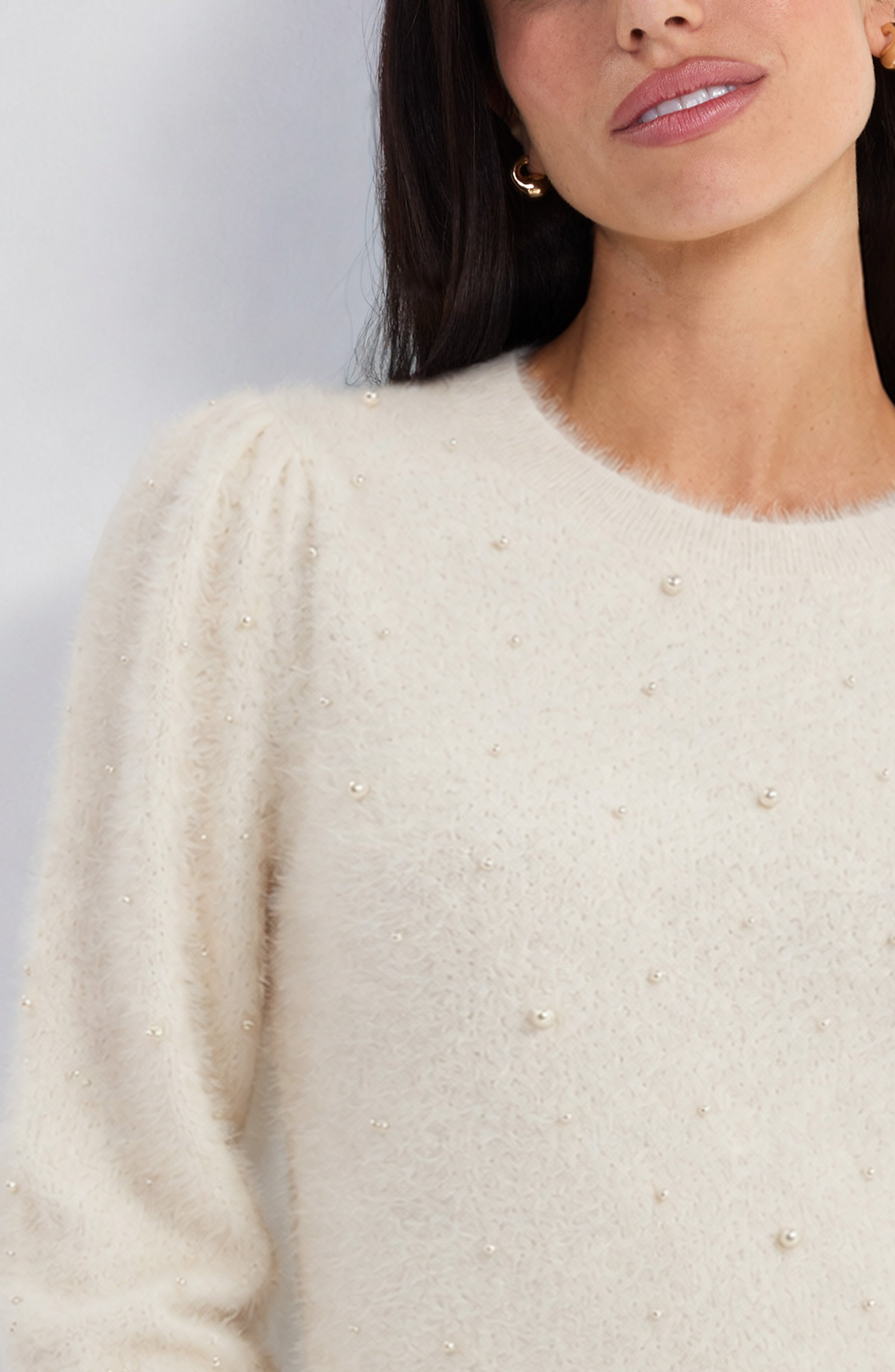 Close-up of the pearl embellishments on the ivory Liverpool feather yarn sweater