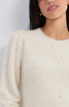 Close-up of the pearl embellishments on the ivory Liverpool feather yarn sweater