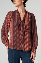 Front view of the Long Sleeve Woven Blouse with Neck Tie in Burgundy Rust geometric stripe, tied in a bow at the neck